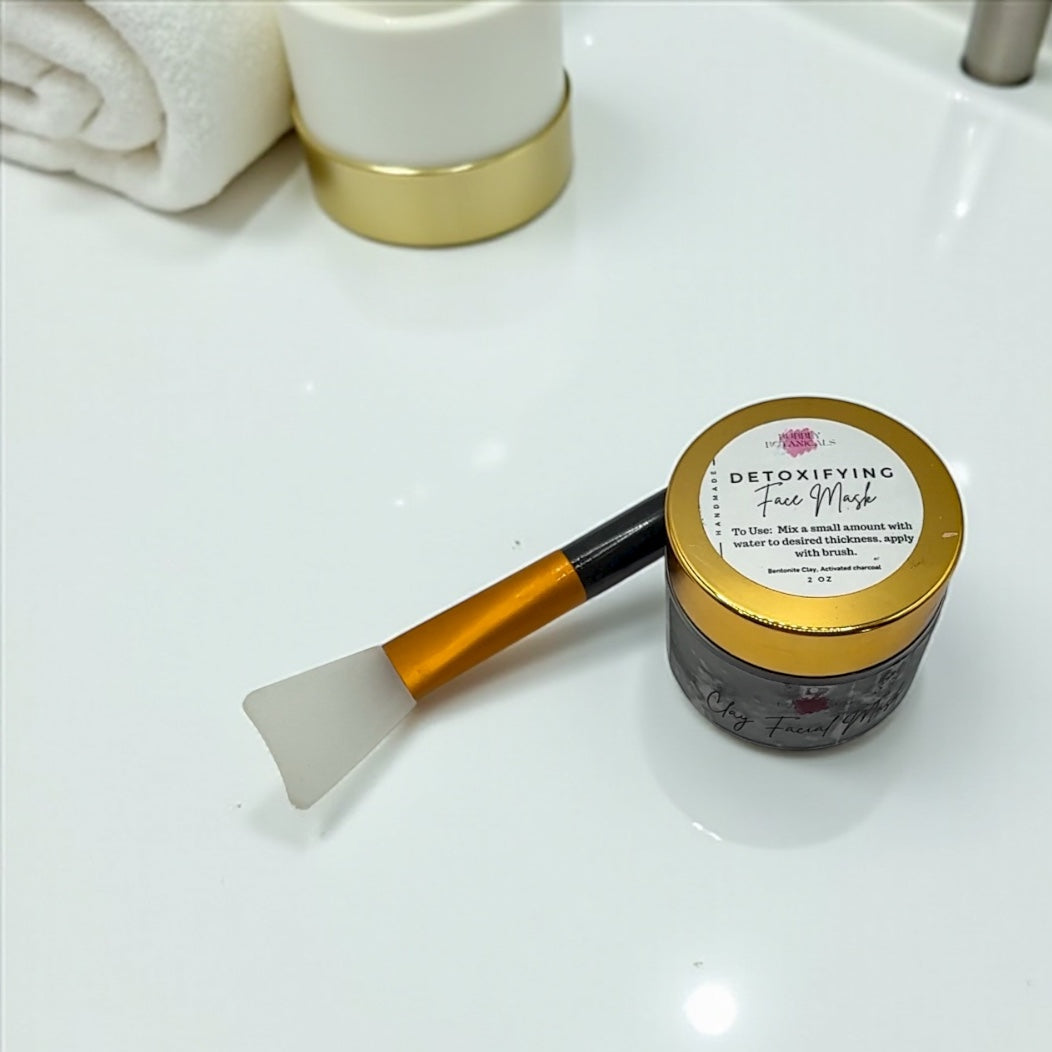 Jar of detoxifying face mask with applicator on a bathroom counter