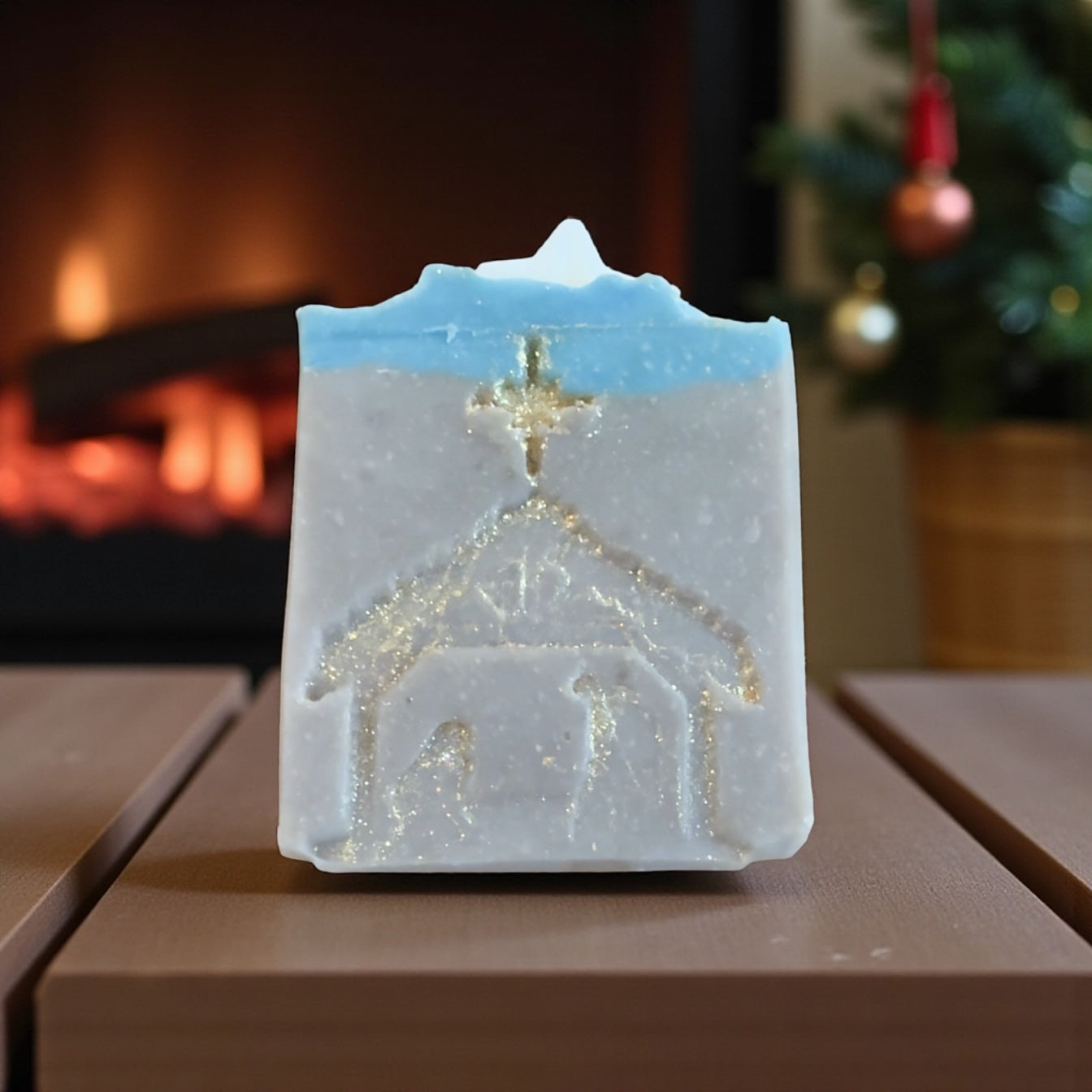 Decorative candle shaped like a church with a cross, placed on a wooden surface with a blurred background.