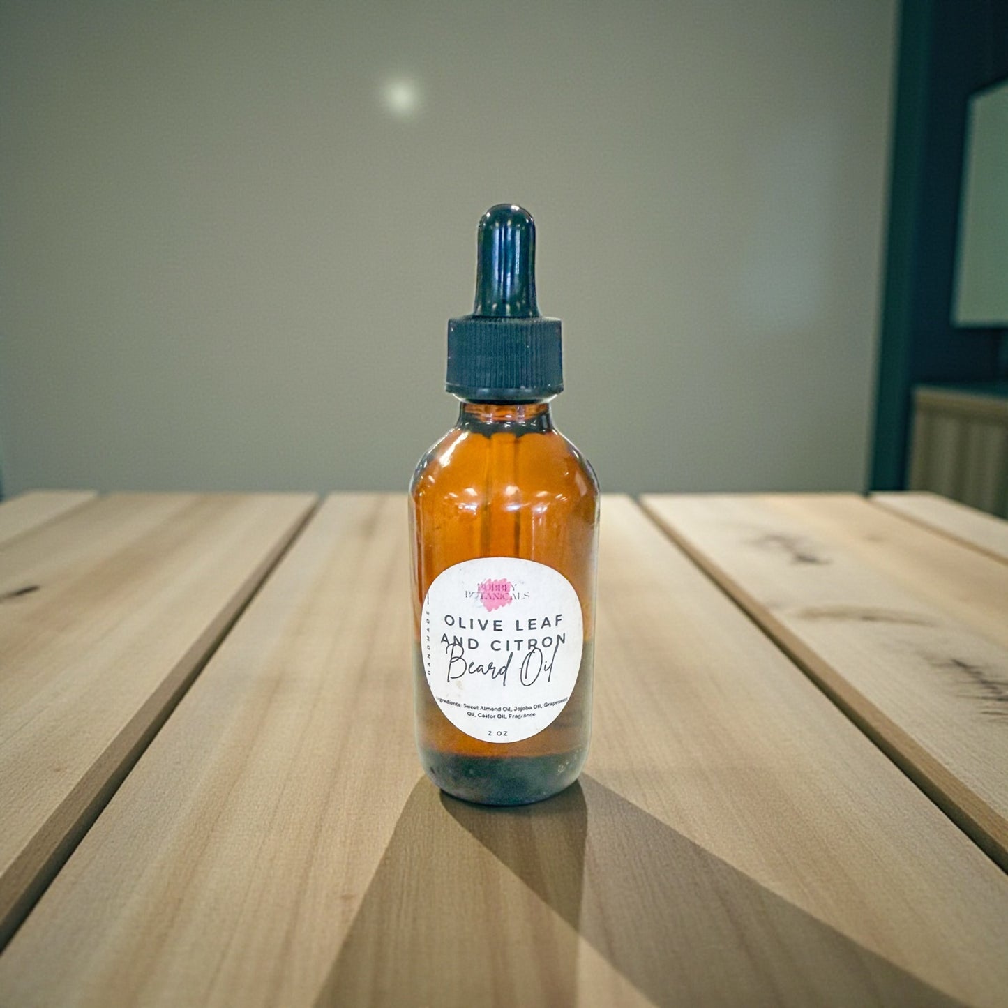 Bottle of olive leaf and citron body oil on a wooden surface