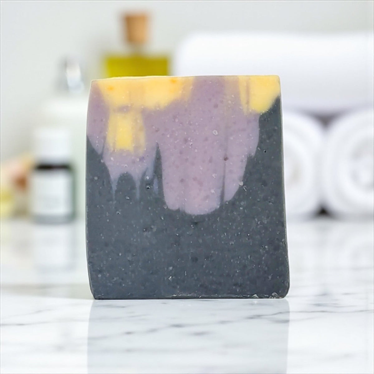 Black Violet and Saffron Tallow Soap Bar with purple and yellow design on a marble surface