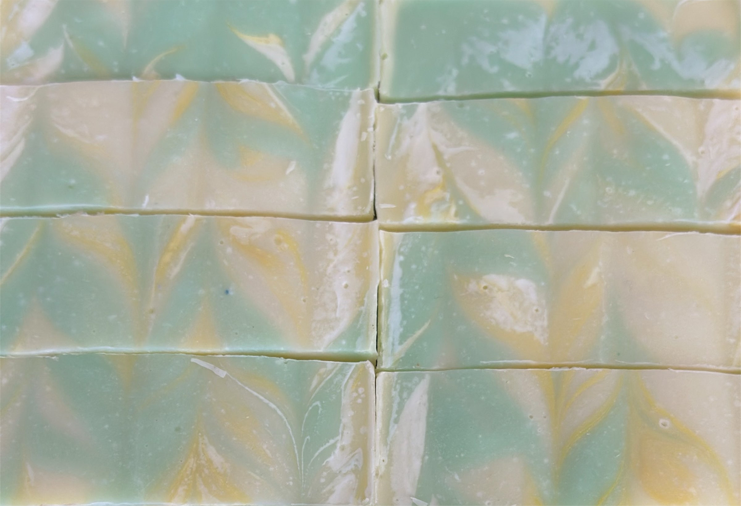 Green and yellow marbled soap bars arranged in a grid pattern.