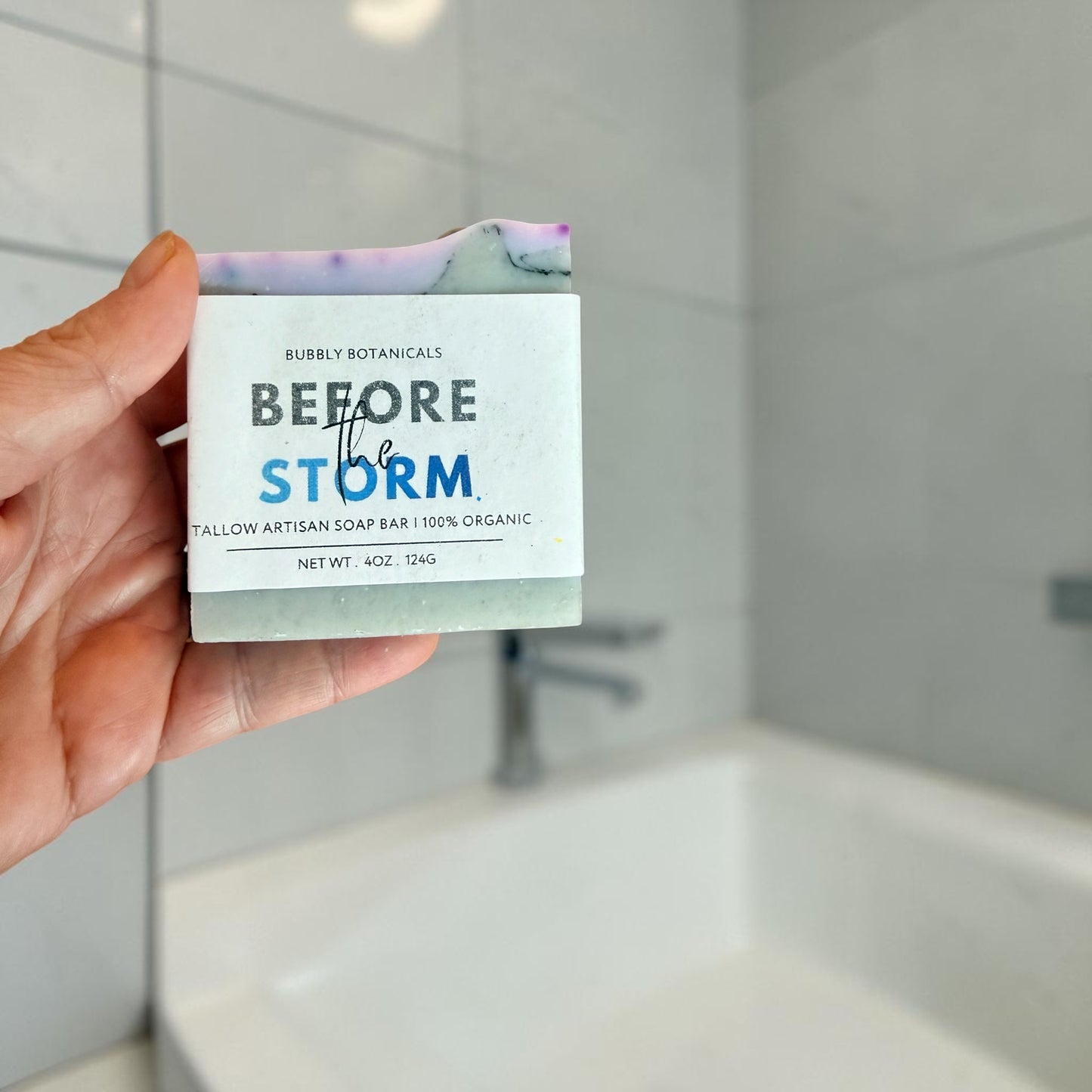 Before the storm tallow soap being held by a hand in the bathroom