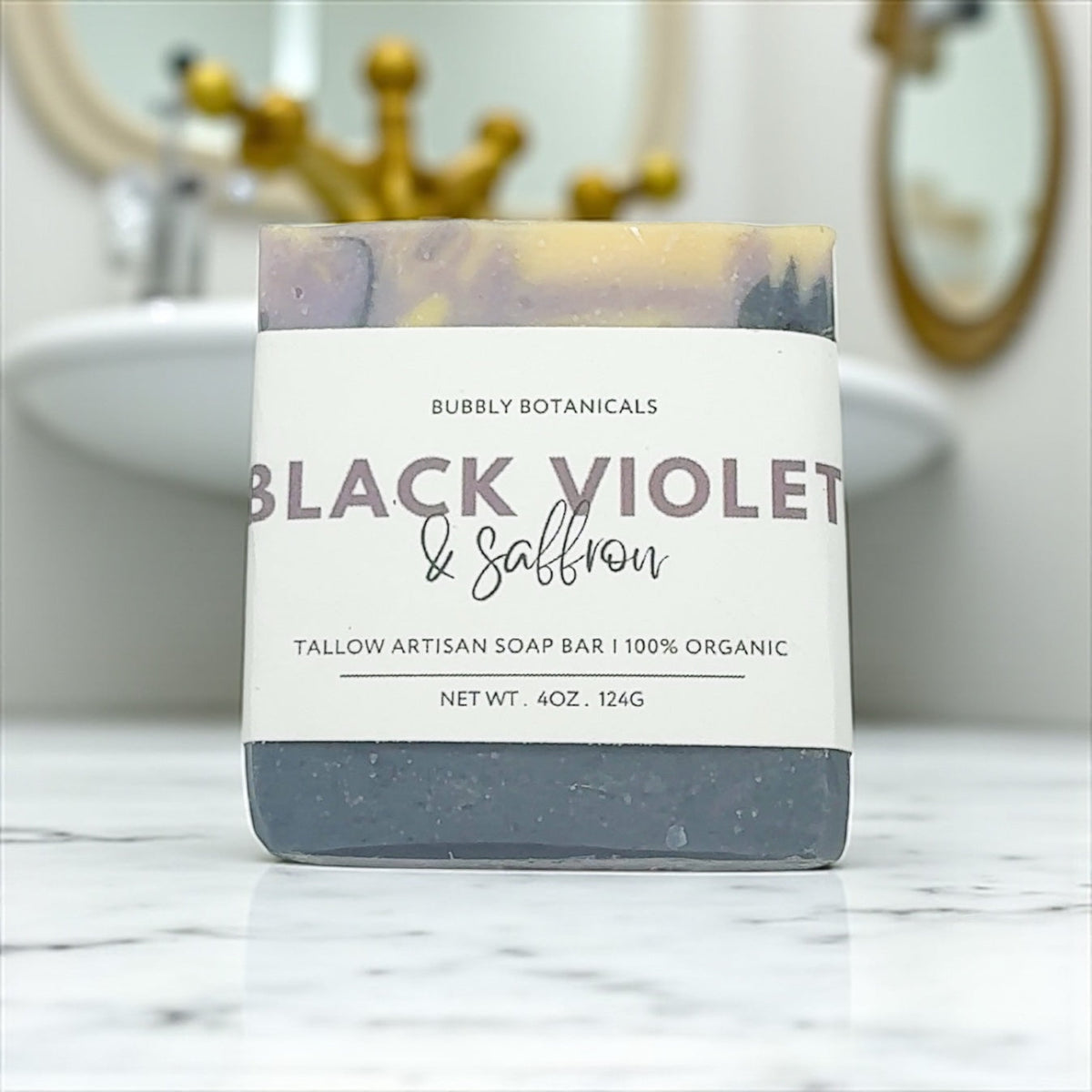 Bar of tallow soap with 'Black Violet and Saffron' label on a marble surface