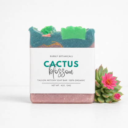 Bar of tallow soap with 'Cactus Blossom' label and small succulent plant on a white background