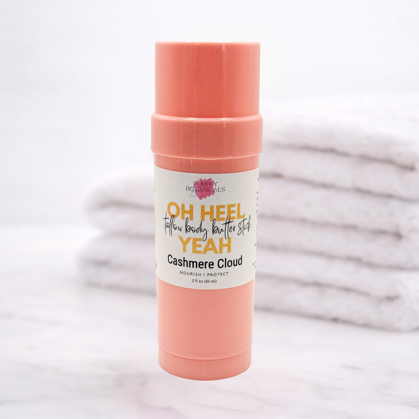 Pink body butter stick with a label on a light background