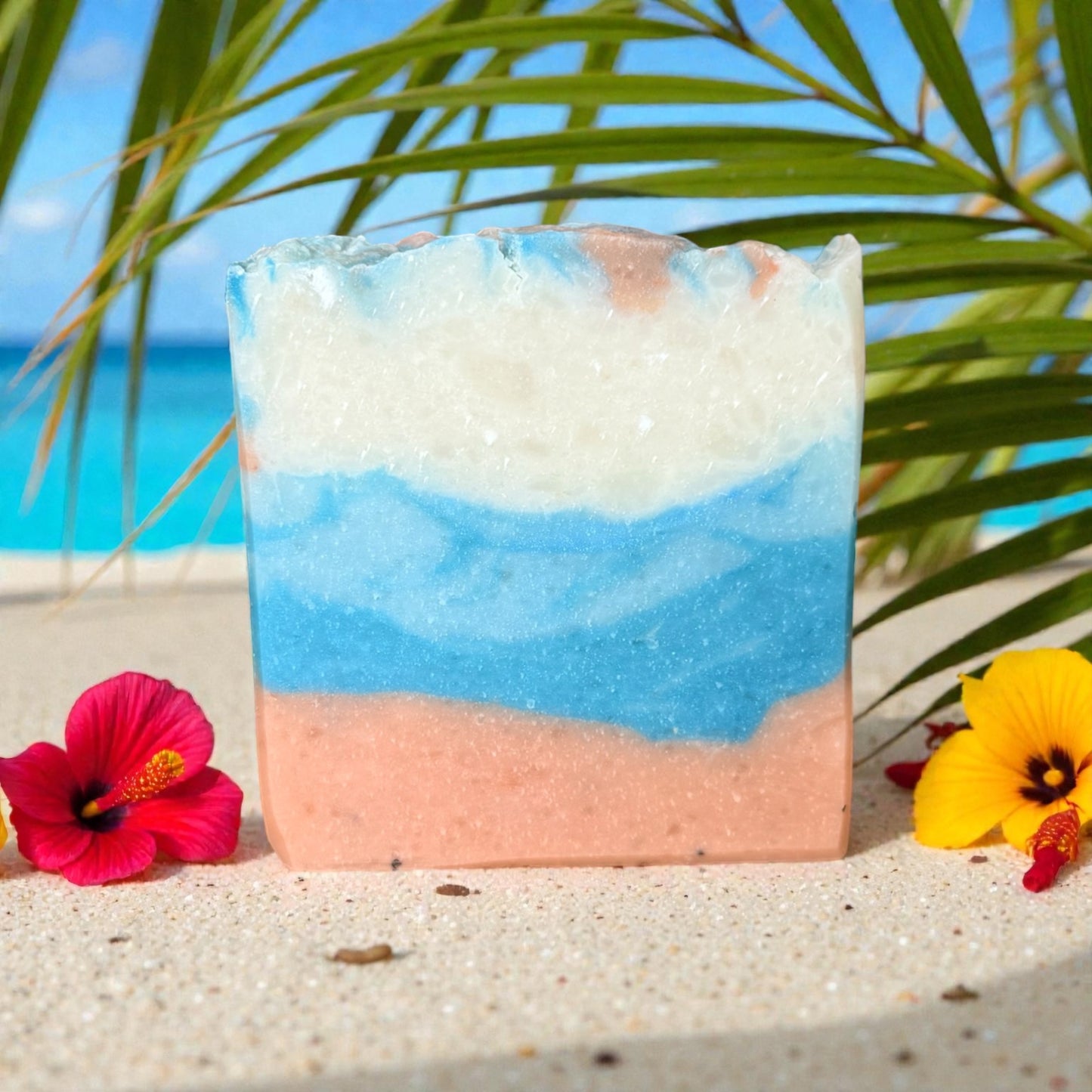 Artistic hawaiian hibiscus tallow soap bar with beach design on sand with flowers and palm leaves
