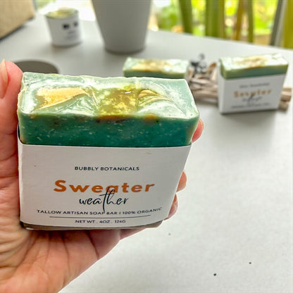 Sweater weather tallow soap swirl top with a background of a concrete table with other soaps on it