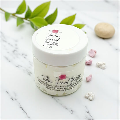 Jar of Jellow Facial Butter on a marble surface with green leaves and flowers.