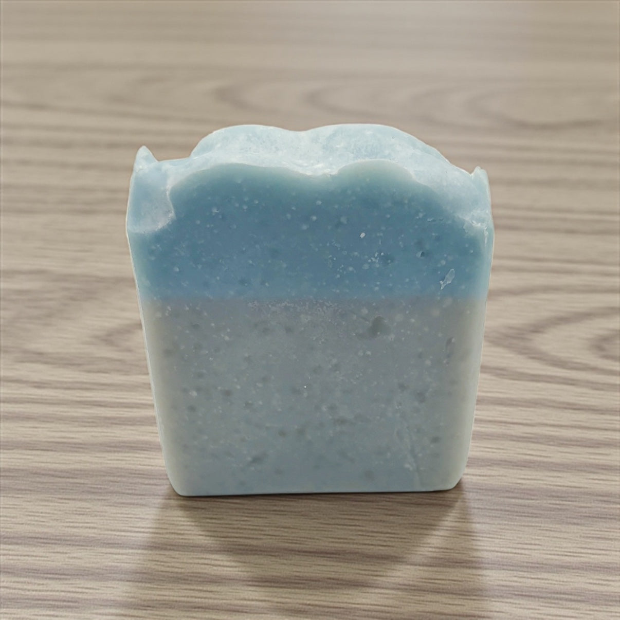 Bar of soap with a layered texture on a wooden surface