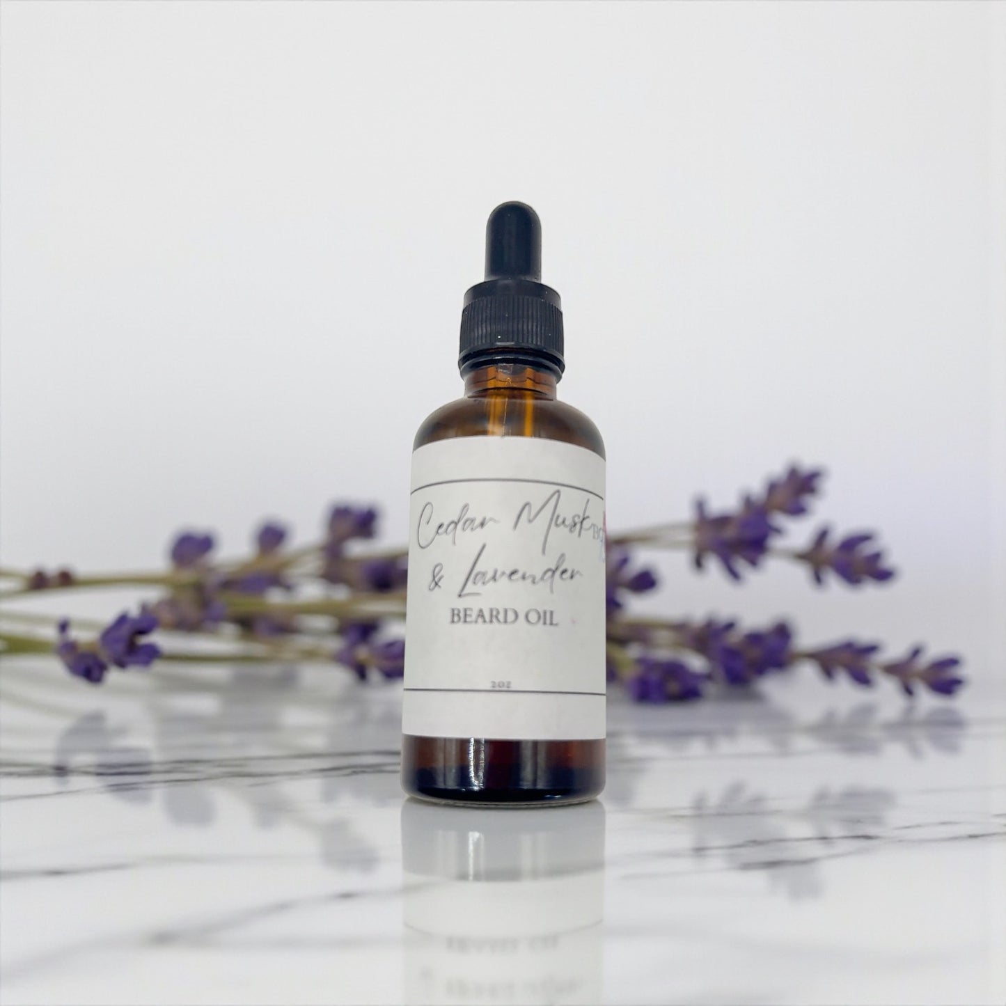 Bottle of Cedar Mist & Lavender beard oil with lavender flowers in the background