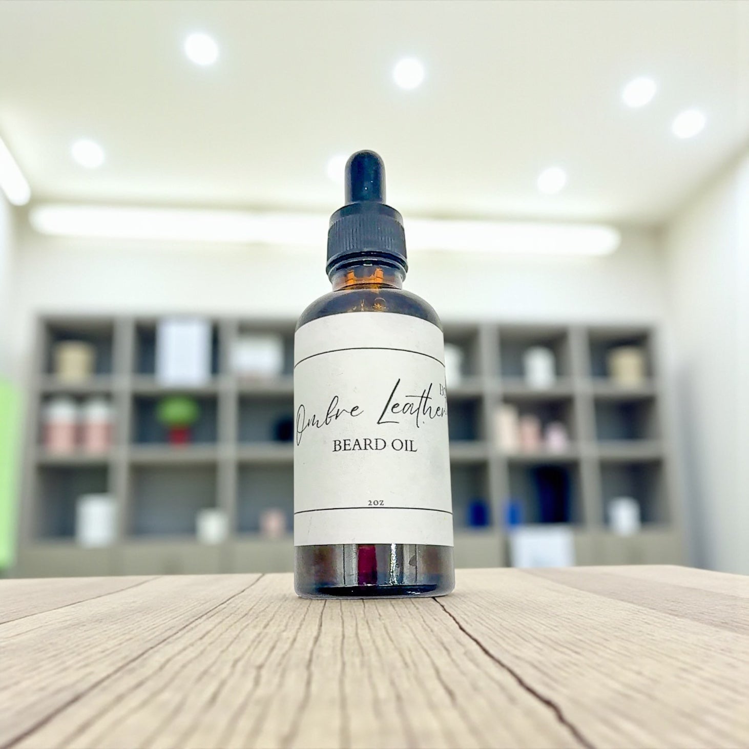 Bottle of 'Oxbow Leather' beard oil on a wooden surface with a blurred background