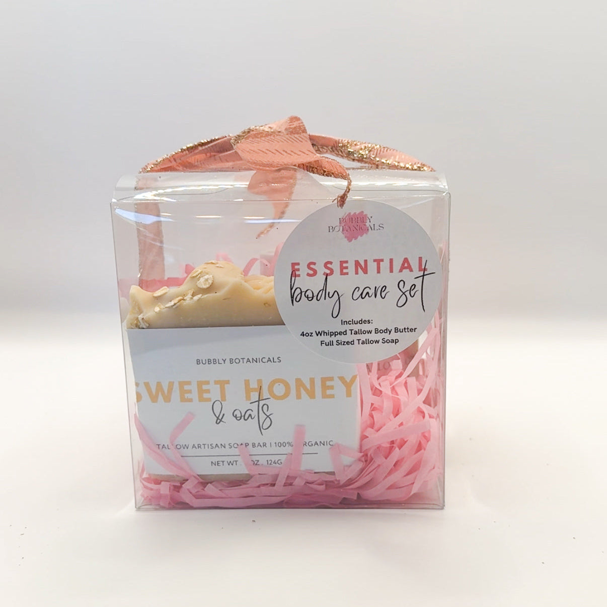 Essential body care set with soap and bath salts in a clear box on a white background