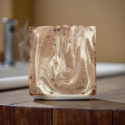 Marbled soap bar on a wooden surface with a blurred bathroom background