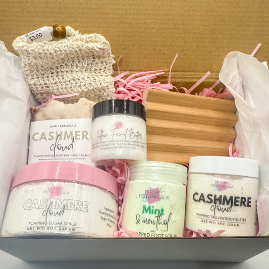 Assorted beauty products including jars and a soap in a box on a white surface.