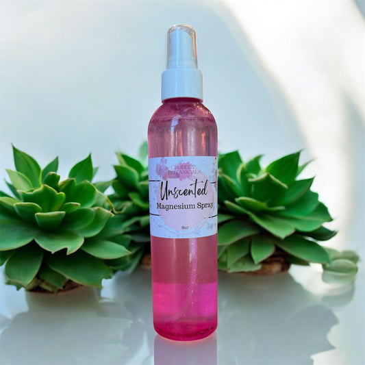 Pink magnesium spray bottle with a label in front of green succulents