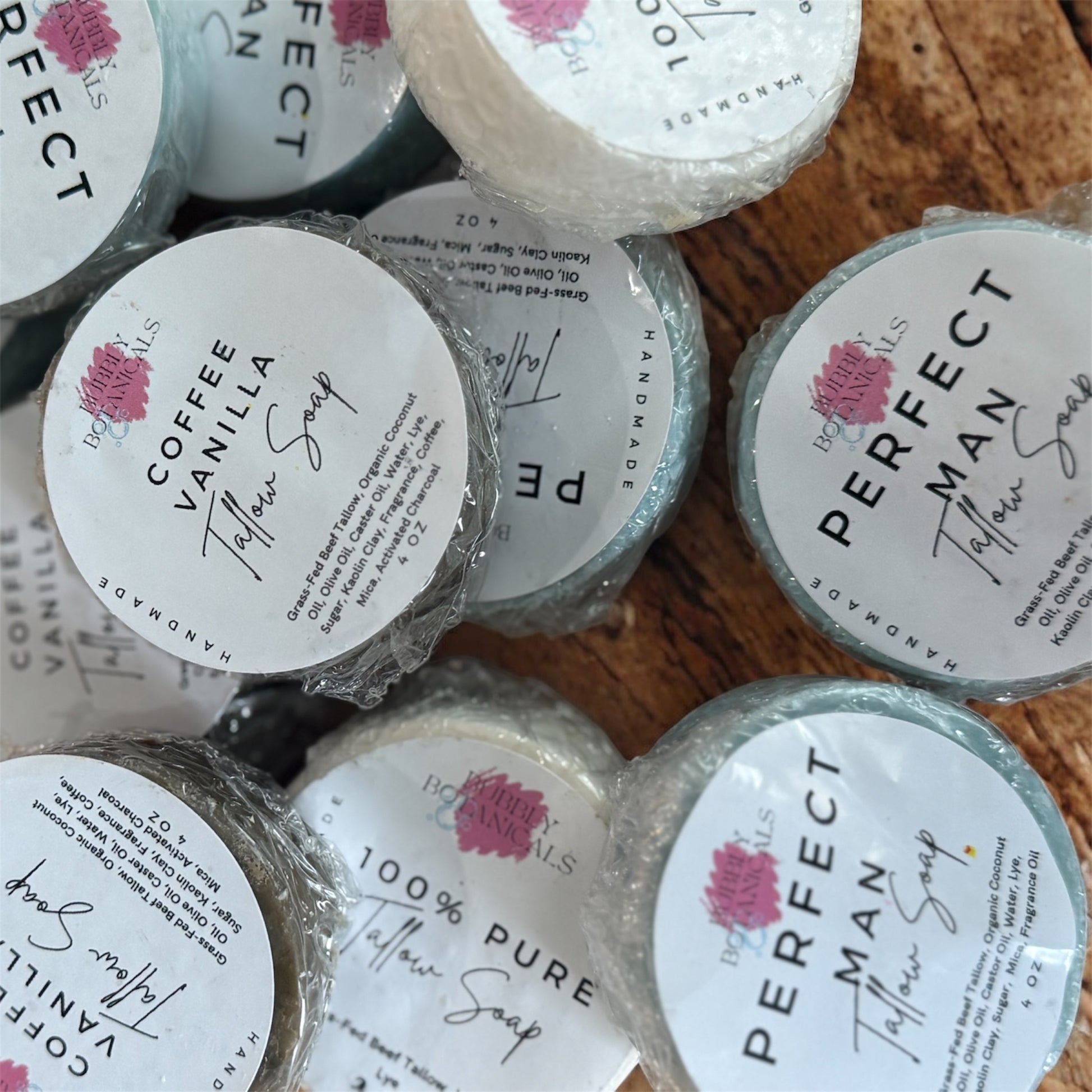 A group of different scented tallow mini soaps on a wooden table