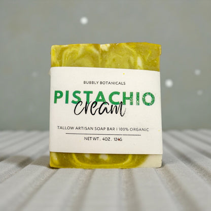 Bar of soap with a label indicating 'Pistachio Cream' from Bubbly Botanicals on a neutral background.