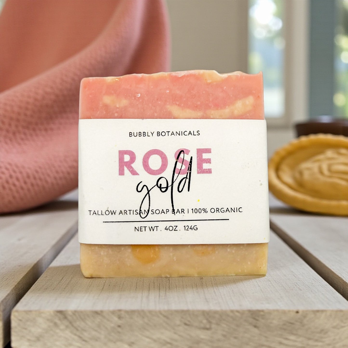 Bar of soap with a 'Bubbly Botanicals Rose Gold' label on a wooden surface.