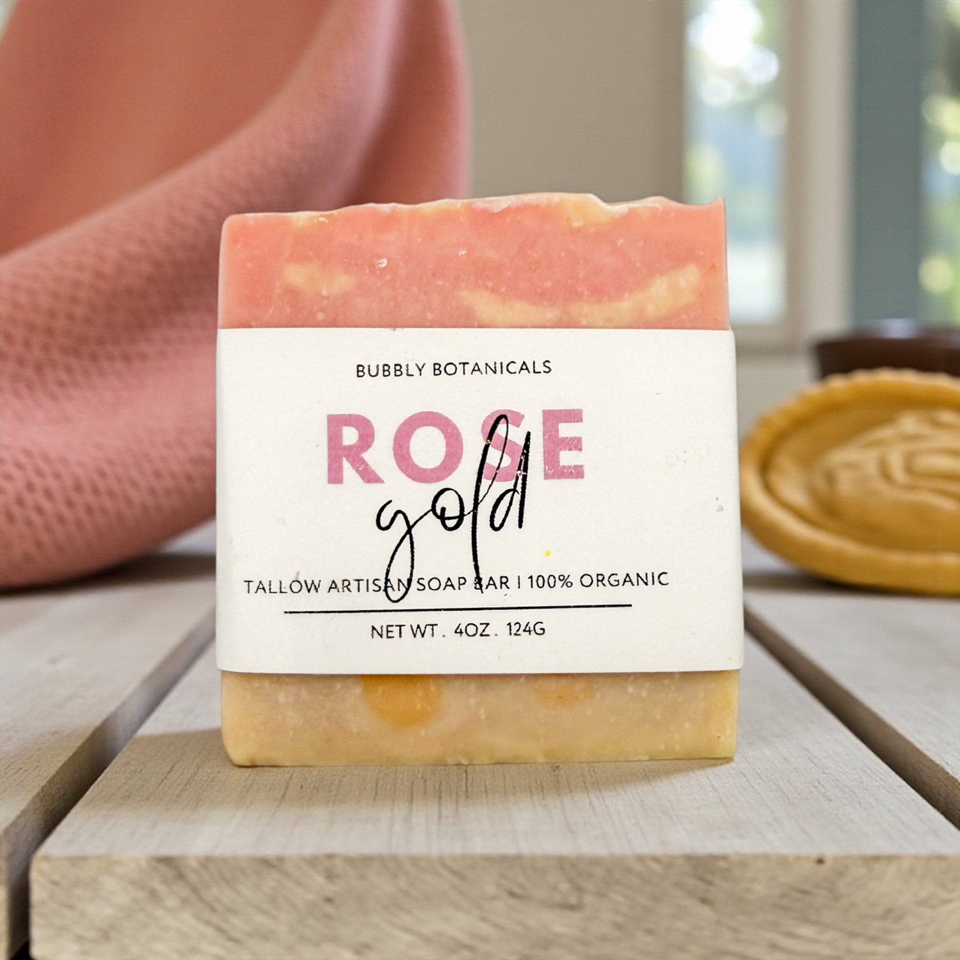 Bar of soap with a 'Bubbly Botanicals Rose Gold' label on a wooden surface.
