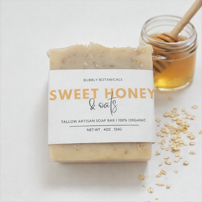 Bar of tallow soap labeled 'Sweet Honey & Oats' with a jar of honey and oats on a light background