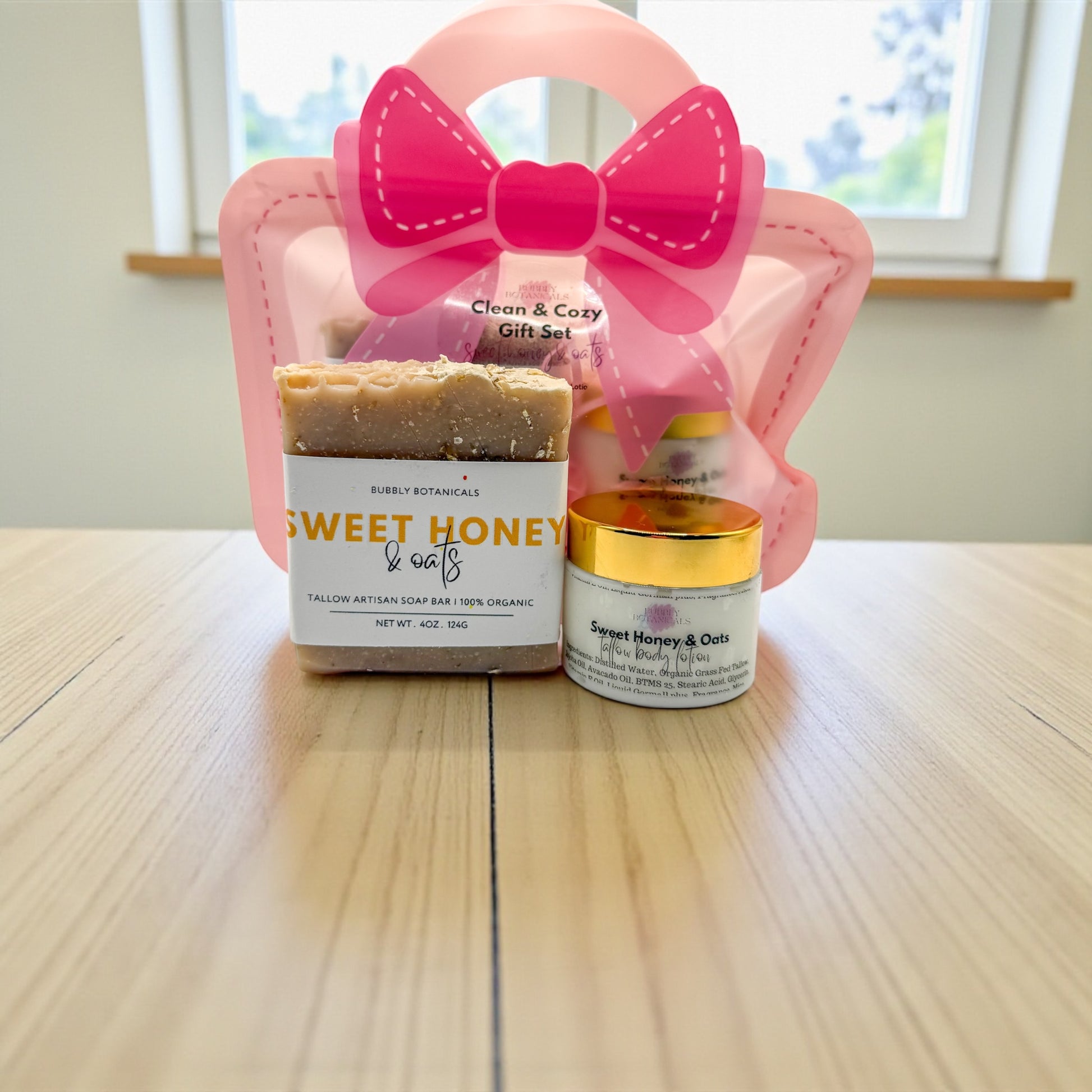 Gift set with soap bar and cream jar labeled 'Sweet Honey & Oats' on a wooden surface.