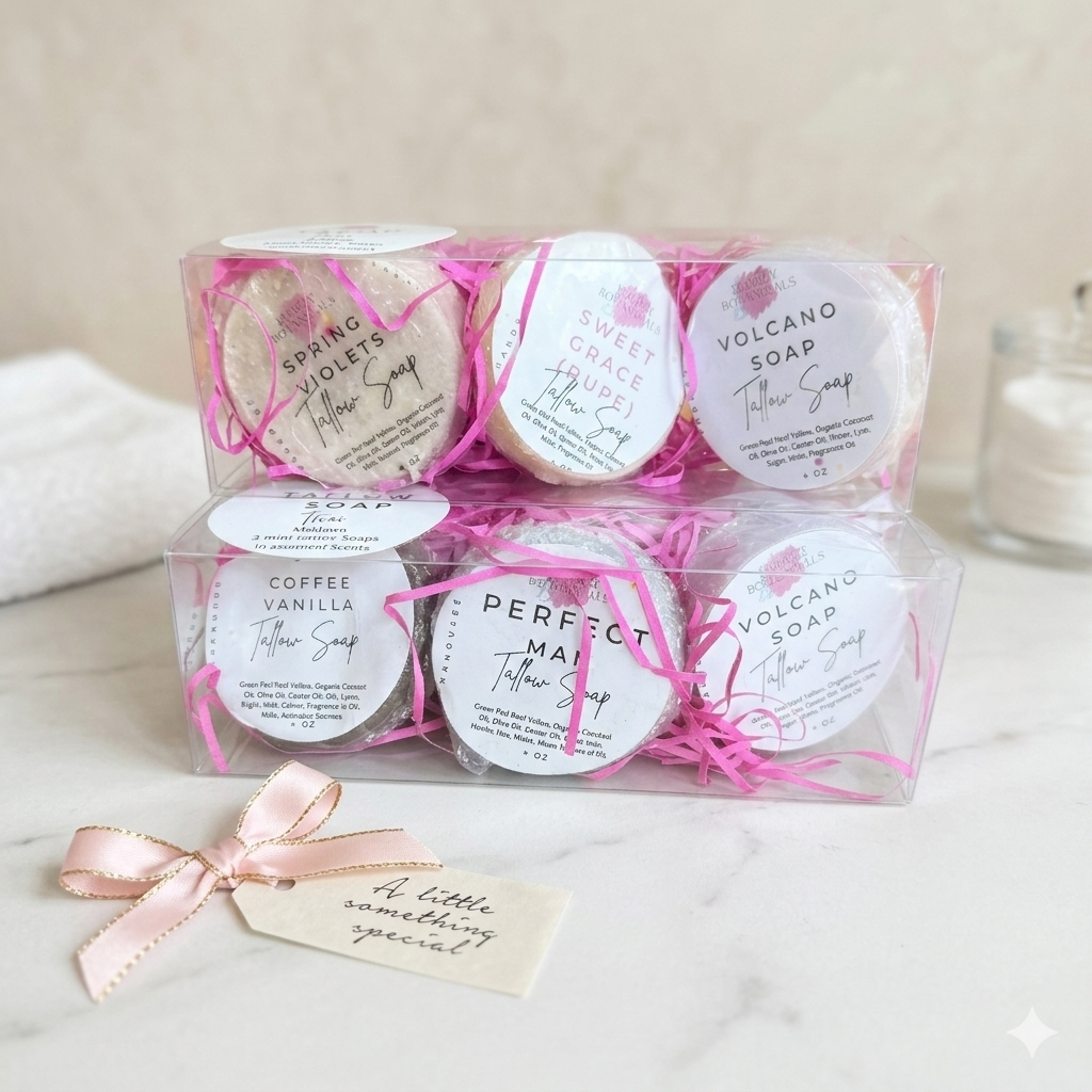 Set of wrapped soaps with labels in a clear box on a marble surface.