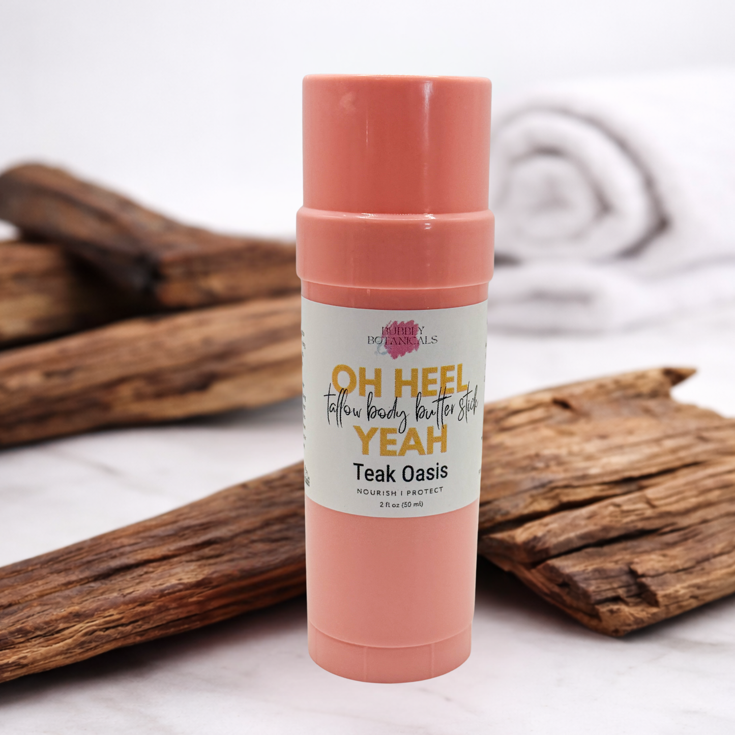 Pink tube of body butter with a label on a wooden surface