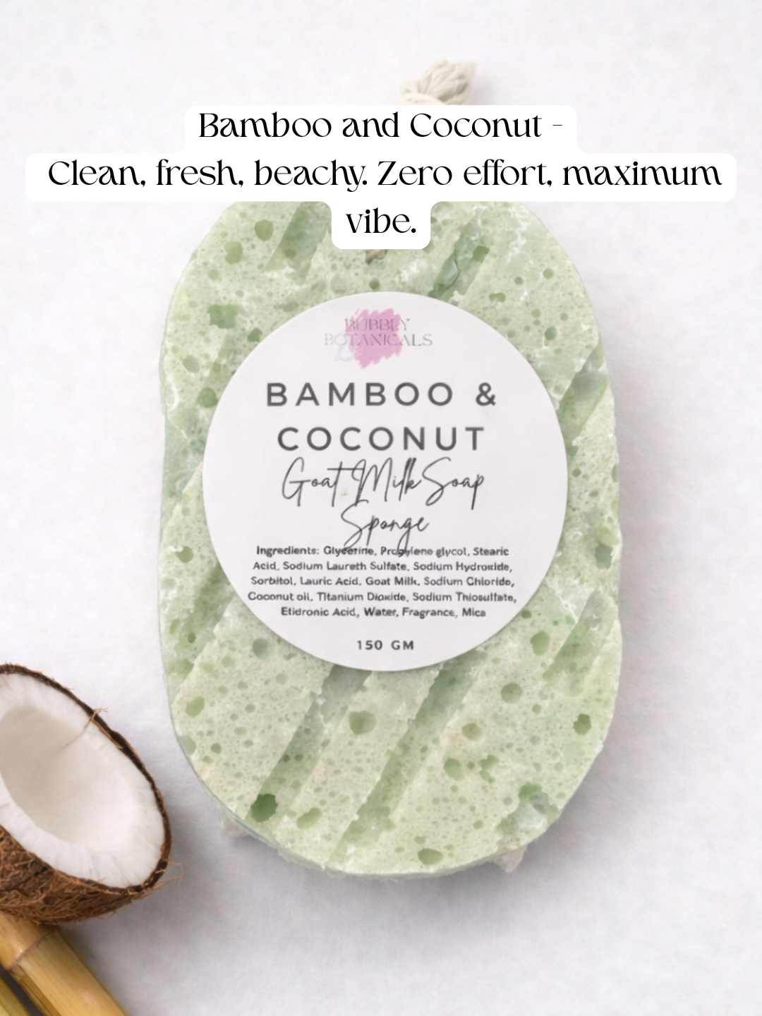 A light green and white speckled goat milk soap sponge bar labeled 'BAMBOO & COCONUT' on a white background, with a half coconut and bamboo stick as props, and text at the top reading 'Bamboo and Coconut - Clean, fresh, beachy. Zero effort, maximum vibe.