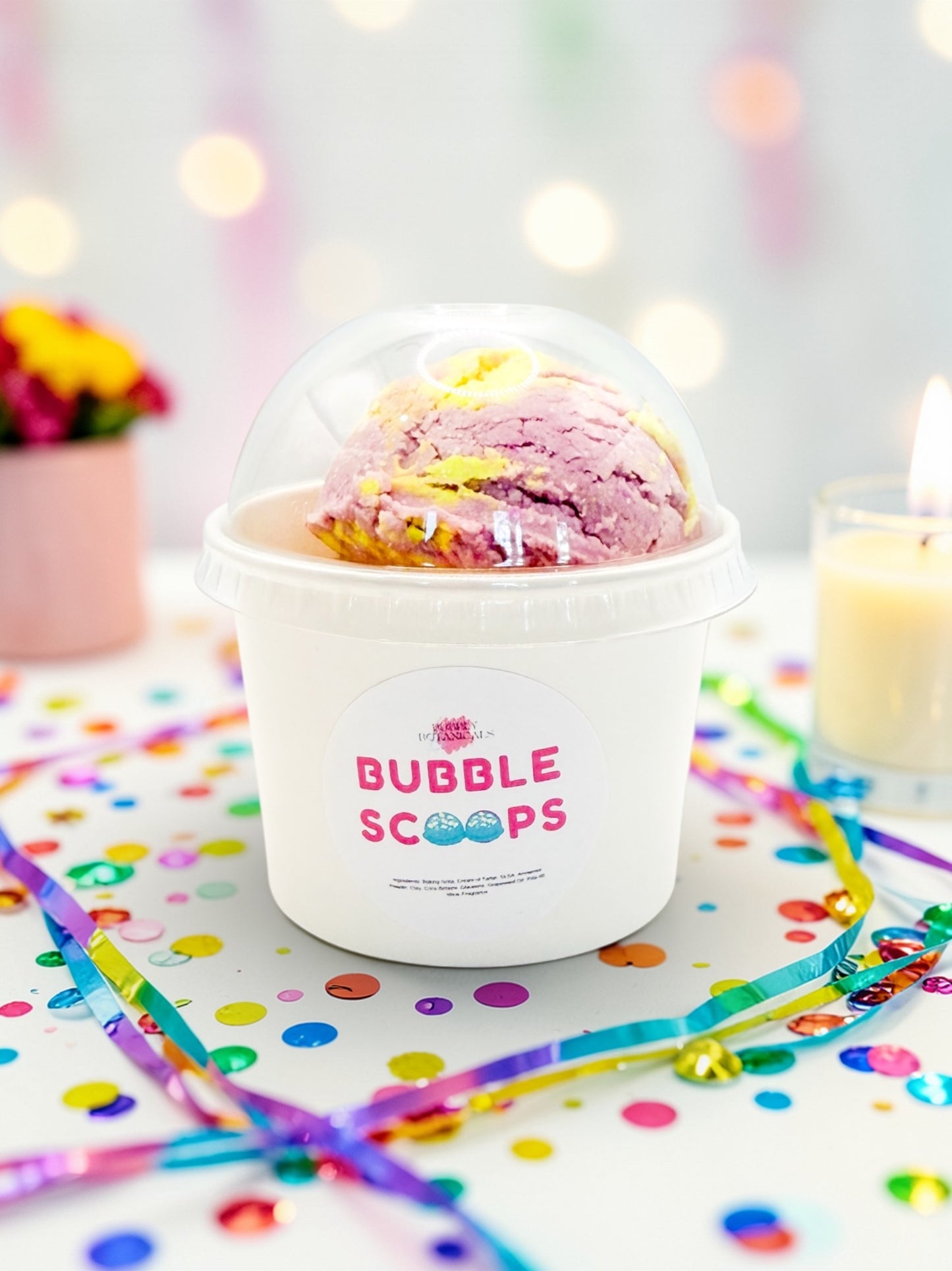 Ice cream in a 'Bubble Scoops' container with colorful straws and confetti on a light background