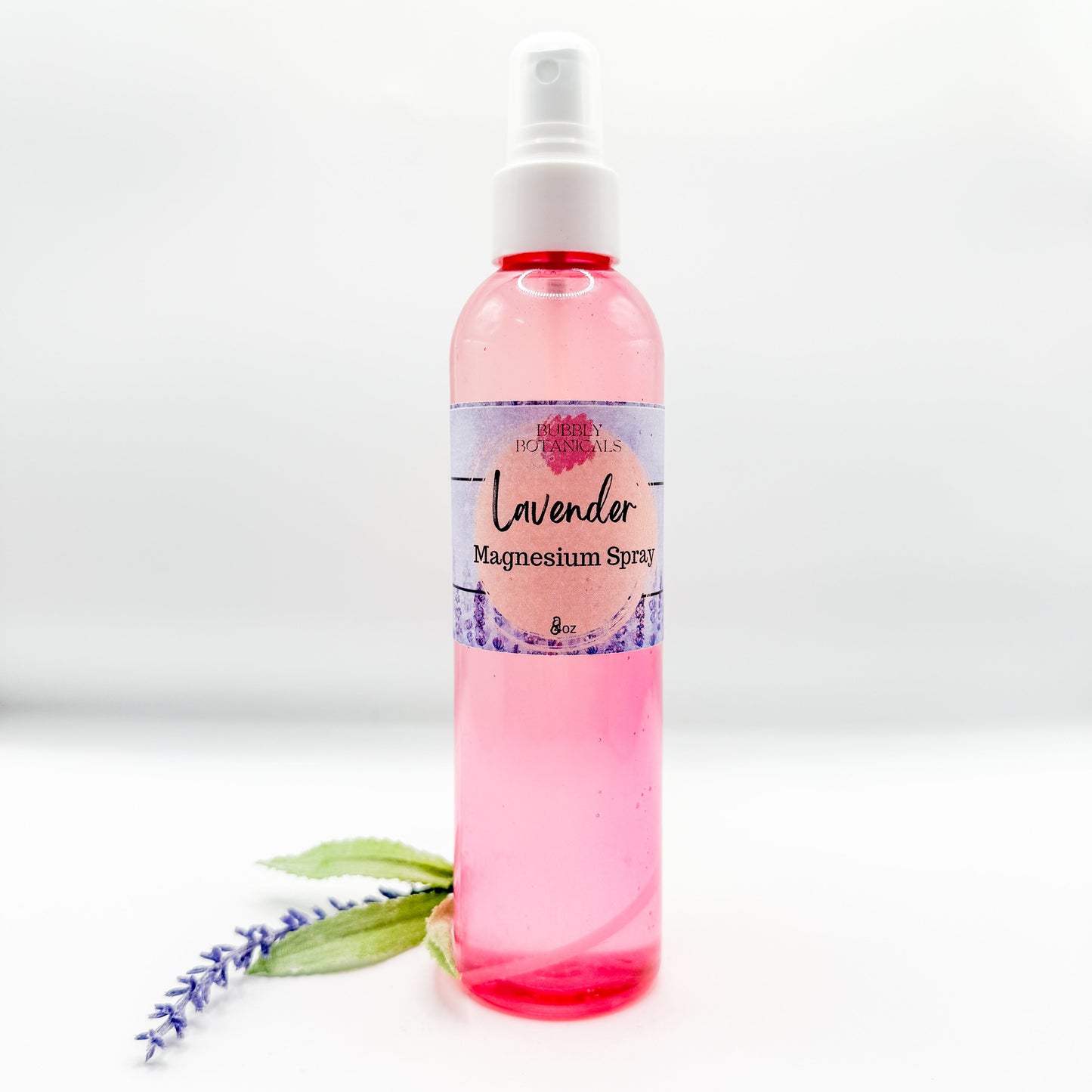 Pink spray bottle labeled 'Lavender Magnesium Spray' on a white background