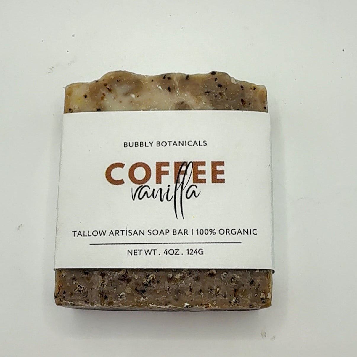 Bar of coffee vanilla tallow soap with a label on a white background
