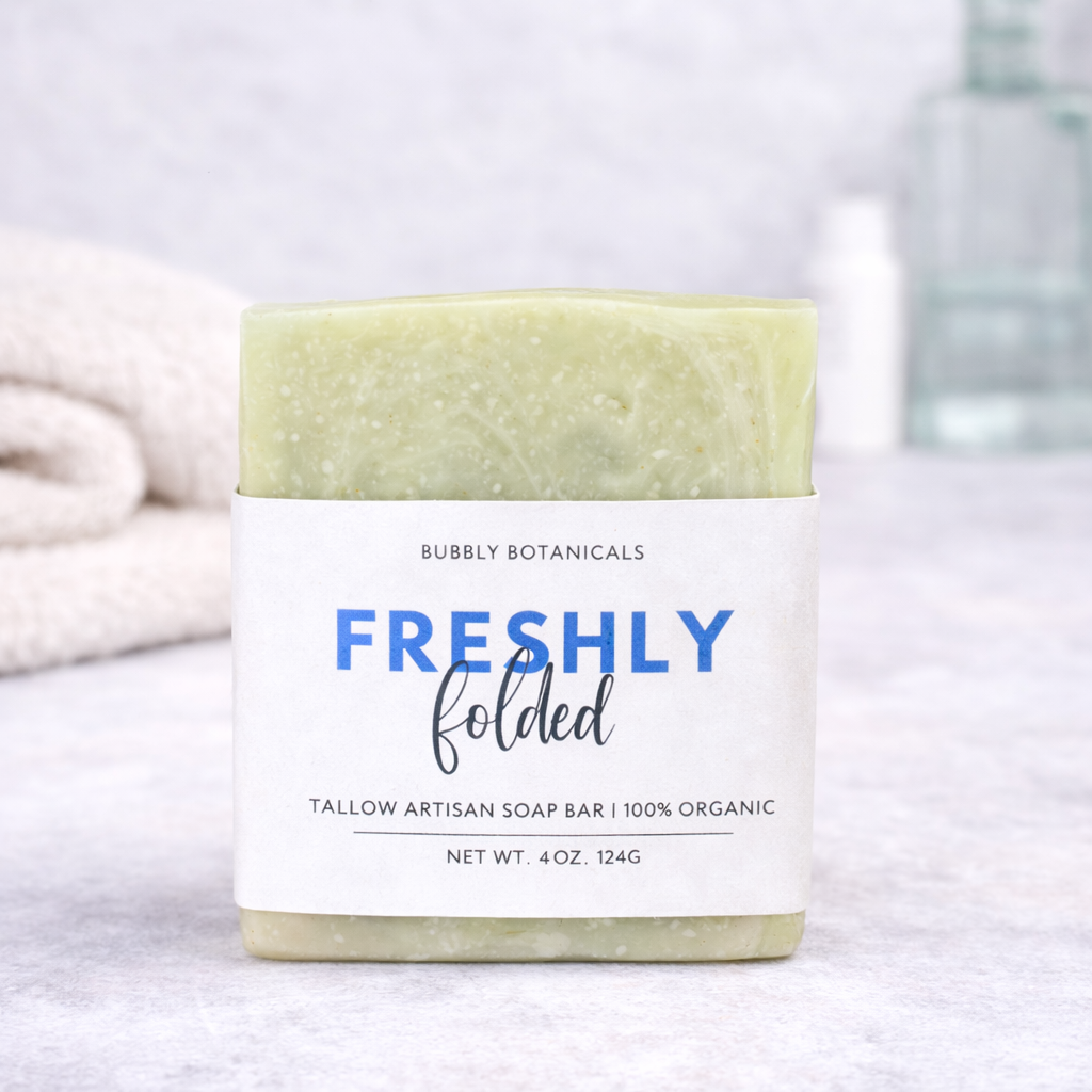 Bar of freshly folded grass-fed tallow soap with a label on a neutral background