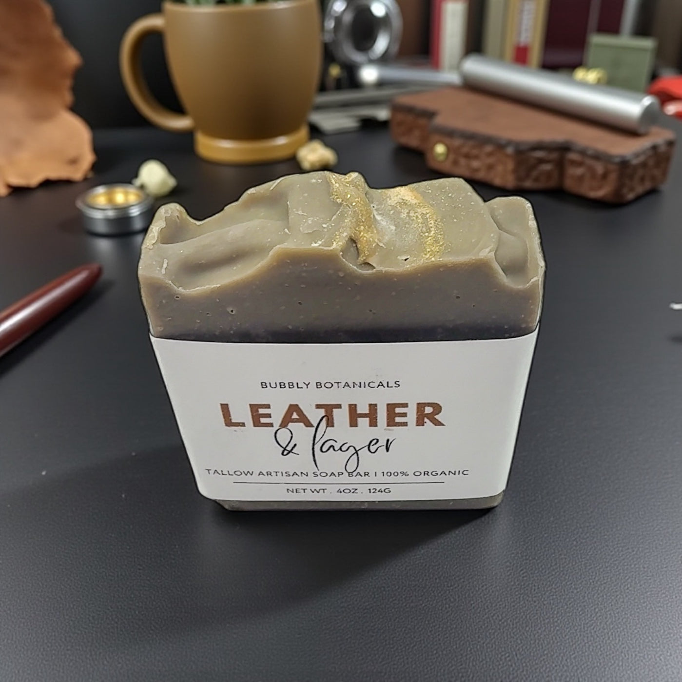 Bar of soap with 'Leather & Lager' branding on a dark surface