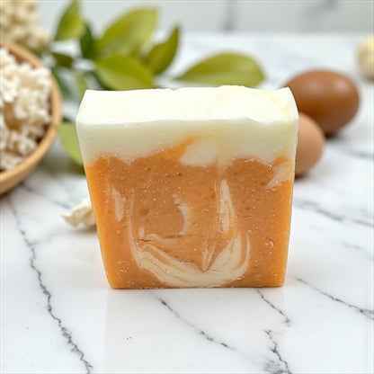 Bar of soap with a marbled design on a marble surface with eggs and leaves in the background