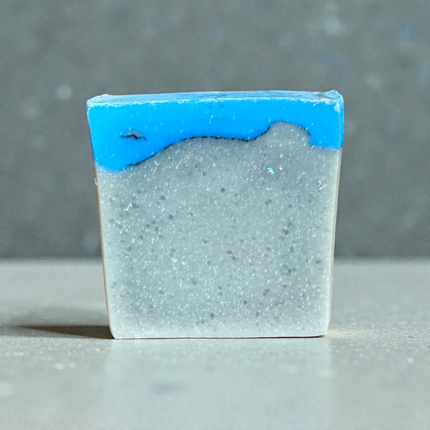 Bar of perfect man tallow soap with a blue top layer on a gray background