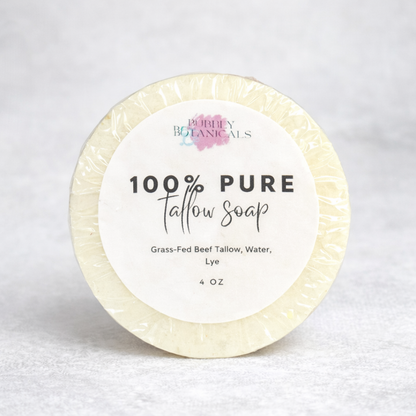 Round pure grass-fed tallow soap bar with a white label on a light gray background