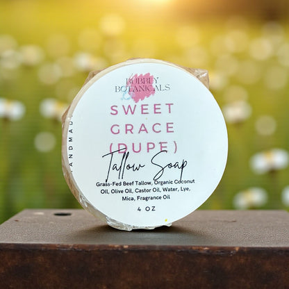 Tallow soap bar with 'Sweet Grace' label on a wooden surface against a blurred natural background